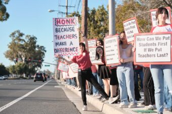 Anaheim Secondary Teachers Association members with signs against layoffs